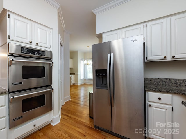 9413 Tillot Dr, Matthews, NC 28105 - kitchen with stainless steel appliances, light wood-style floors, white cabinetry, a chandelier, and dark stone counters