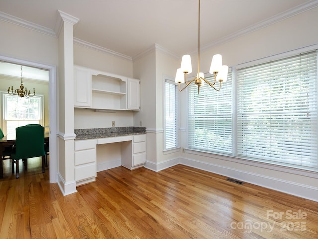 9413 Tillot Dr, Matthews, NC 28105 - kitchen featuring a chandelier, built in desk, open shelves, ornamental molding, and white cabinets