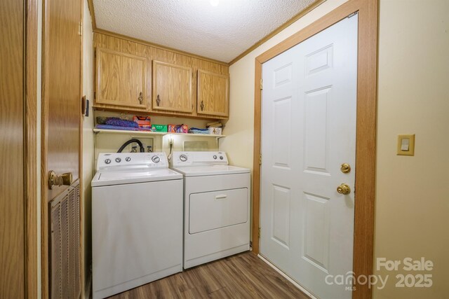 2310 Alexis Lucia Rd, Stanley, NC 28164 - laundry area featuring cabinet space, independent washer and dryer, a textured ceiling, and wood finished floors