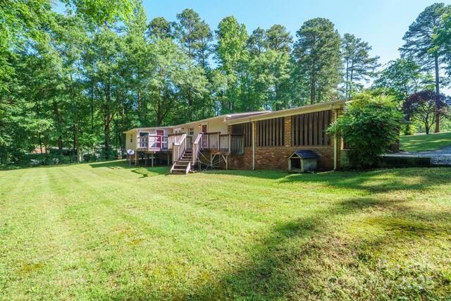 2310 Alexis Lucia Rd, Stanley, NC 28164 - back of property with brick siding, a lawn, a deck, and stairs