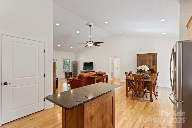99 Pinecrest Estates Dr, Flat Rock, NC 28731 - kitchen with freestanding refrigerator, a kitchen island, a ceiling fan, light wood-type flooring, and high vaulted ceiling