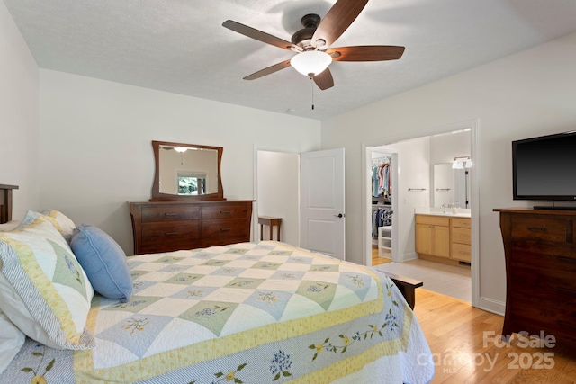99 Pinecrest Estates Dr, Flat Rock, NC 28731 - bedroom with a walk in closet, light wood finished floors, connected bathroom, and a ceiling fan