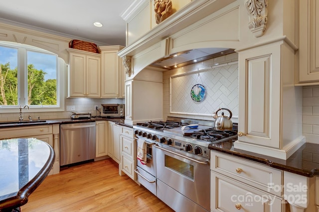 340 Harrison Rd, Roebuck, SC 29376 - kitchen with appliances with stainless steel finishes, backsplash, cream cabinets, light wood-style floors, and recessed lighting