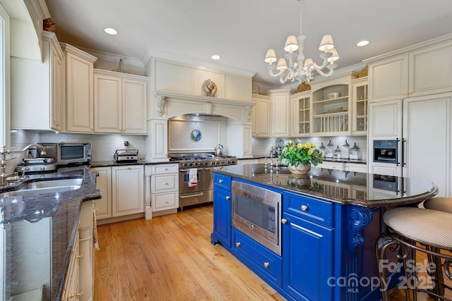 340 Harrison Rd, Roebuck, SC 29376 - kitchen featuring appliances with stainless steel finishes, blue cabinetry, a chandelier, a kitchen breakfast bar, and light wood finished floors