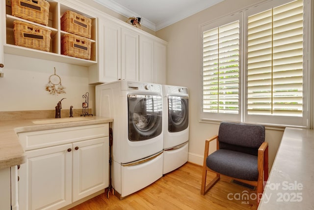 340 Harrison Rd, Roebuck, SC 29376 - laundry area featuring washing machine and dryer, cabinet space, ornamental molding, and light wood-style flooring
