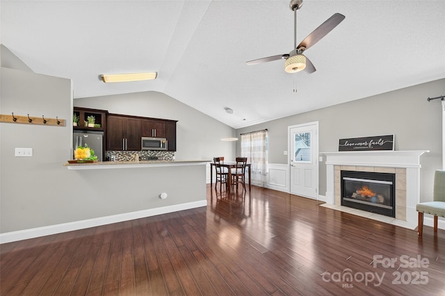 118 Milroy Ln Unit 171, Mooresville, NC 28115 - living area featuring vaulted ceiling, ceiling fan, wood finished floors, and a tiled fireplace