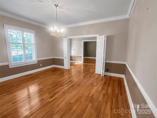 208 N Gaston St, Kings Mountain, NC 28086 - spare room with a chandelier, light wood-style flooring, and crown molding