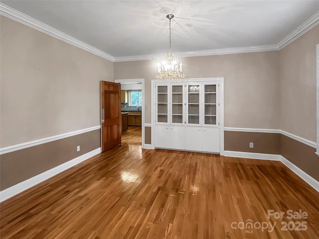 208 N Gaston St, Kings Mountain, NC 28086 - unfurnished dining area with a chandelier, wood finished floors, and crown molding