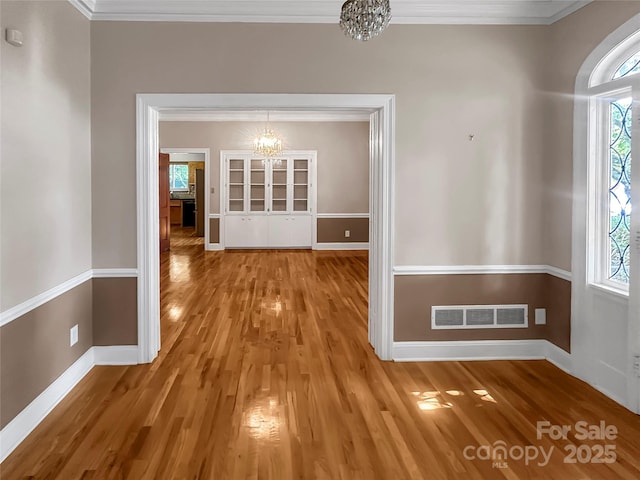208 N Gaston St, Kings Mountain, NC 28086 - unfurnished dining area with a chandelier, wood finished floors, and ornamental molding