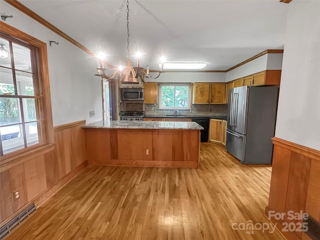 208 N Gaston St, Kings Mountain, NC 28086 - kitchen with stainless steel appliances, a peninsula, wainscoting, ornamental molding, and a chandelier