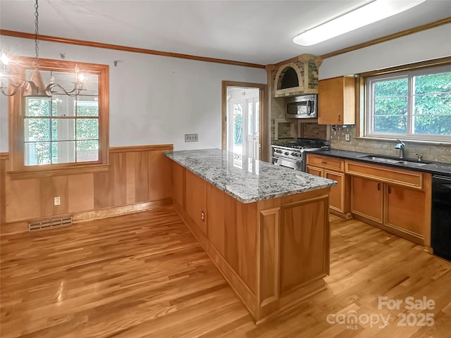208 N Gaston St, Kings Mountain, NC 28086 - kitchen featuring stainless steel appliances, a chandelier, wainscoting, light wood-type flooring, and crown molding