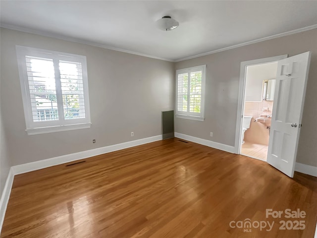 208 N Gaston St, Kings Mountain, NC 28086 - unfurnished bedroom featuring crown molding, wood finished floors, and ensuite bath