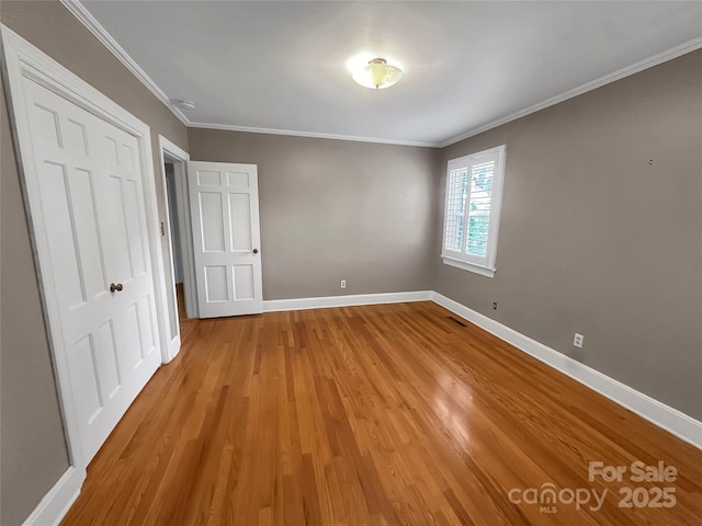 208 N Gaston St, Kings Mountain, NC 28086 - unfurnished bedroom featuring light wood-type flooring, a closet, and crown molding