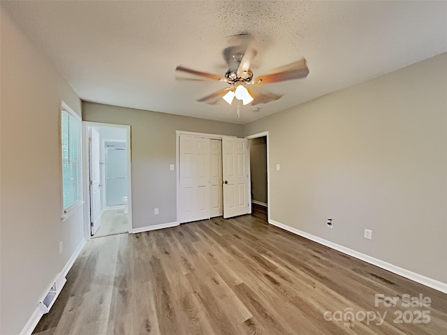 7420 Castlebar Rd, Charlotte, NC 28270 - unfurnished bedroom featuring wood finished floors, a closet, ceiling fan, and connected bathroom