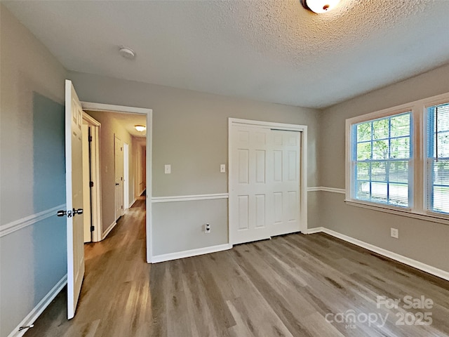 7420 Castlebar Rd, Charlotte, NC 28270 - unfurnished bedroom with wood finished floors, a textured ceiling, and a closet