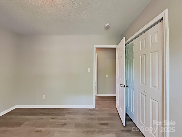 7420 Castlebar Rd, Charlotte, NC 28270 - unfurnished bedroom with wood finished floors, a closet, and a textured ceiling