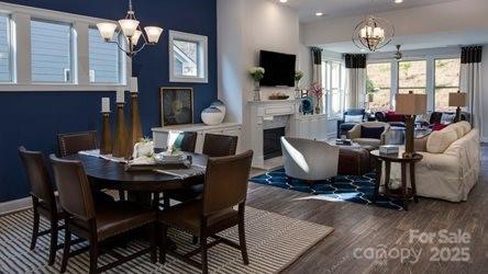 8414 Profit Ln, Charlotte, NC 28215 - dining area featuring a chandelier, wood finished floors, a fireplace, and recessed lighting