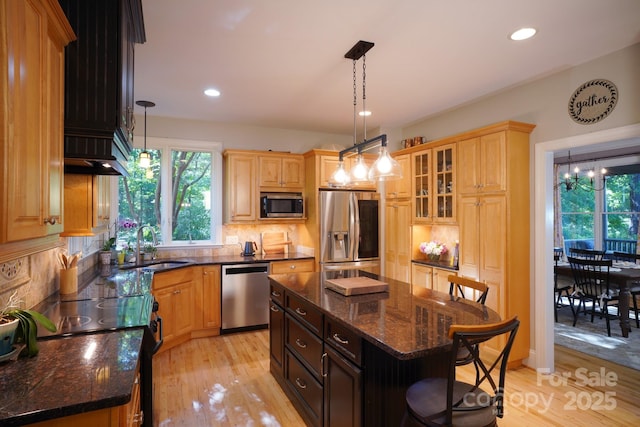 25 Madelyn Ln, Fairview, NC 28730 - kitchen with stainless steel appliances, a kitchen breakfast bar, light wood-style flooring, backsplash, and recessed lighting