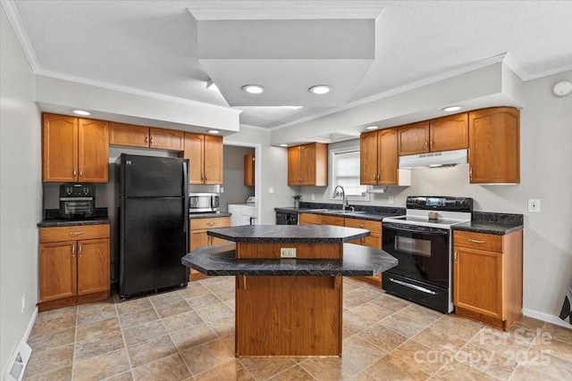 1764 Tomlinson Loop, Connelly Springs, NC 28612 - kitchen featuring range with electric stovetop, freestanding refrigerator, washing machine and dryer, under cabinet range hood, and stainless steel microwave