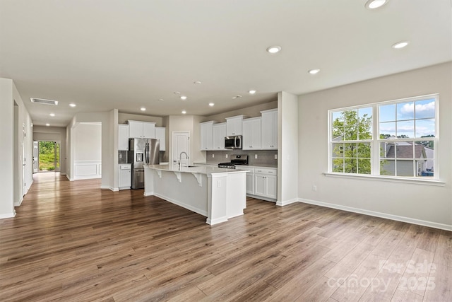 5846 Oak Branch Cir, Maiden, NC 28650 - kitchen featuring stainless steel appliances, wood finished floors, a kitchen breakfast bar, recessed lighting, and white cabinets