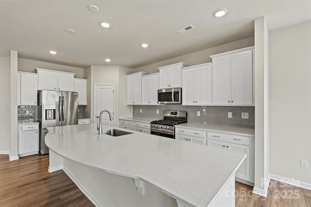 5846 Oak Branch Cir, Maiden, NC 28650 - kitchen featuring appliances with stainless steel finishes, a large island, white cabinetry, dark wood-style flooring, and tasteful backsplash