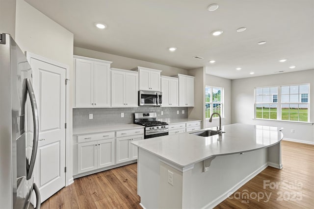5846 Oak Branch Cir, Maiden, NC 28650 - kitchen with appliances with stainless steel finishes, light wood finished floors, a center island with sink, tasteful backsplash, and recessed lighting