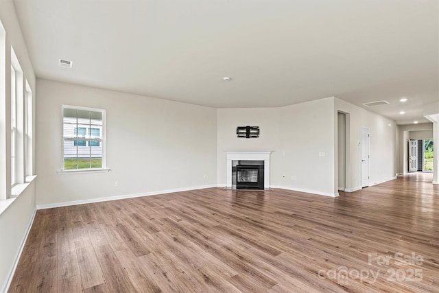 5846 Oak Branch Cir, Maiden, NC 28650 - unfurnished living room featuring wood finished floors, a glass covered fireplace, and recessed lighting