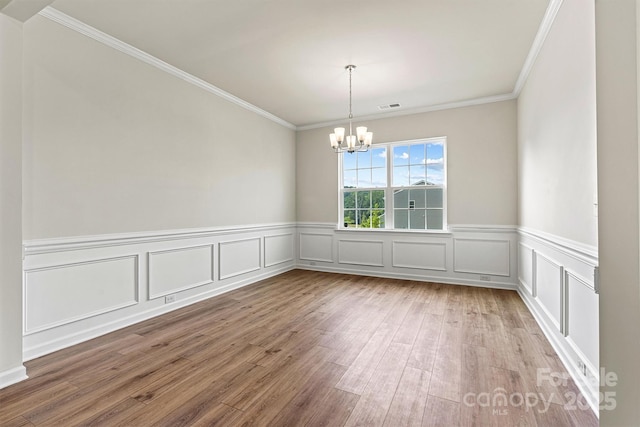 5846 Oak Branch Cir, Maiden, NC 28650 - empty room with a chandelier, wood finished floors, ornamental molding, wainscoting, and a decorative wall