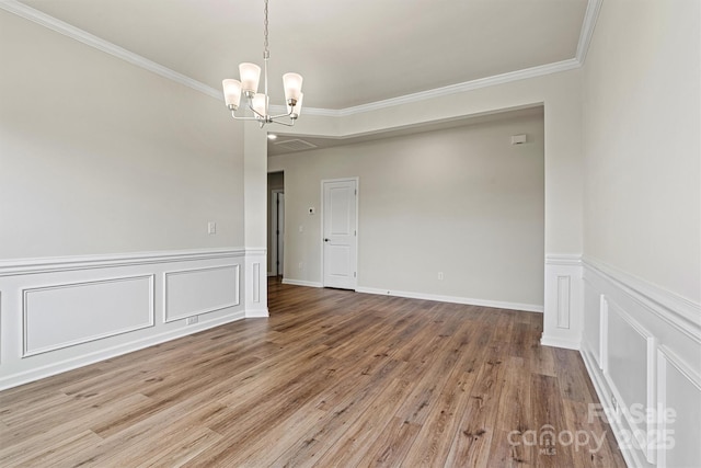 5846 Oak Branch Cir, Maiden, NC 28650 - empty room featuring a chandelier, wood finished floors, crown molding, a wainscoted wall, and a decorative wall