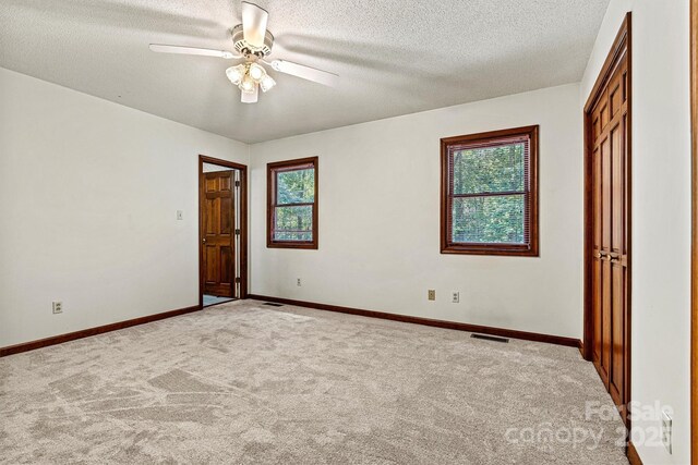 1408 Kensington Cir, Newton, NC 28658 - spare room featuring healthy amount of natural light, light colored carpet, ceiling fan, and a textured ceiling