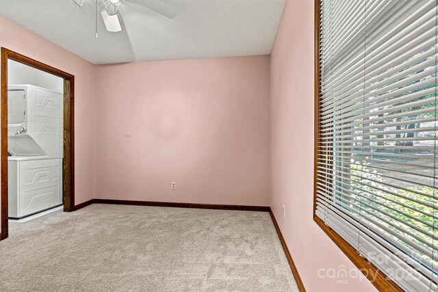 1408 Kensington Cir, Newton, NC 28658 - spare room featuring stacked washer / drying machine, light colored carpet, ceiling fan, and a textured ceiling