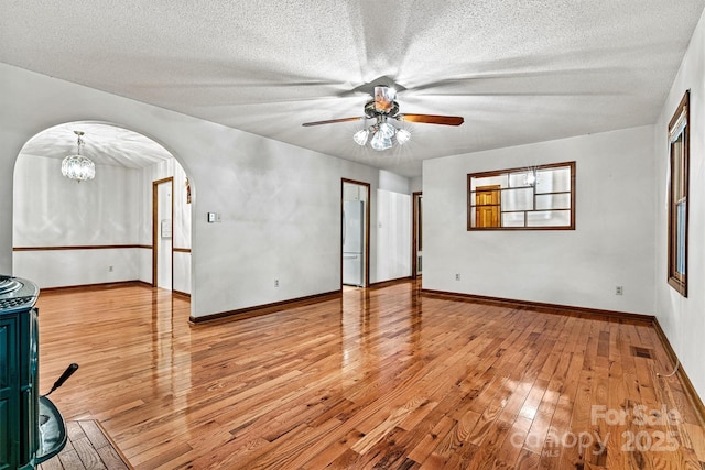 1408 Kensington Cir, Newton, NC 28658 - empty room featuring arched walkways, ceiling fan, hardwood / wood-style floors, a textured ceiling, and a chandelier
