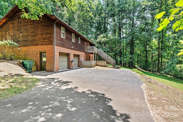1408 Kensington Cir, Newton, NC 28658 - view of side of property with asphalt driveway, a garage, stairway, and brick siding