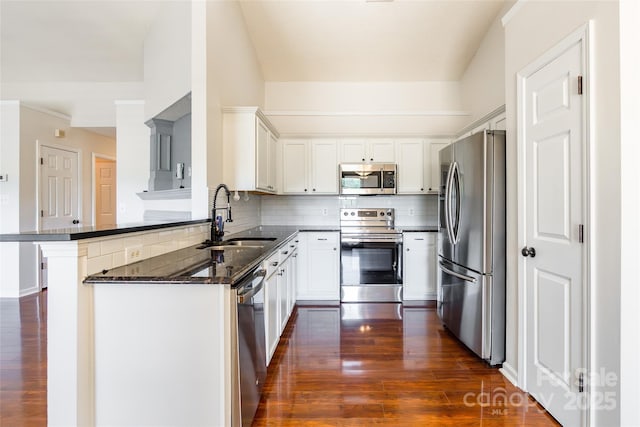 14924 Jerpoint Abby Dr, Charlotte, NC 28273 - kitchen with stainless steel appliances, dark wood-style flooring, decorative backsplash, white cabinetry, and a peninsula