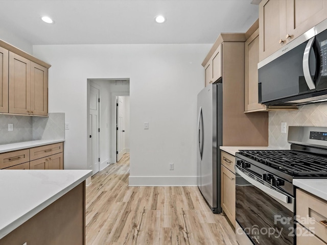 4113 Rutgers Ave, Charlotte, NC 28206 - kitchen with stainless steel appliances, light countertops, decorative backsplash, light wood-style floors, and recessed lighting
