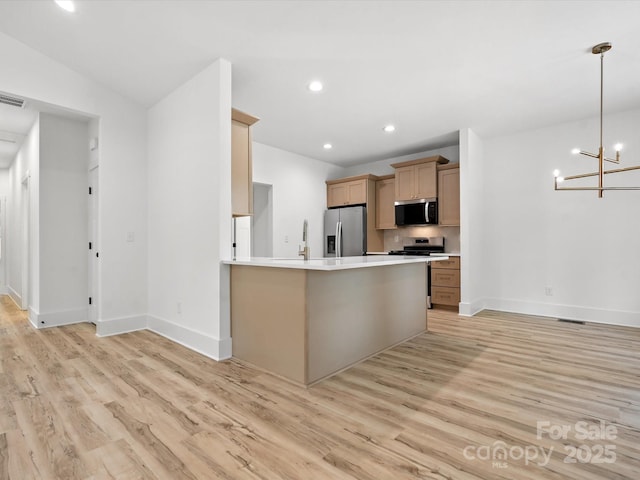 4113 Rutgers Ave, Charlotte, NC 28206 - kitchen with stainless steel appliances, light wood-style floors, a chandelier, light countertops, and recessed lighting