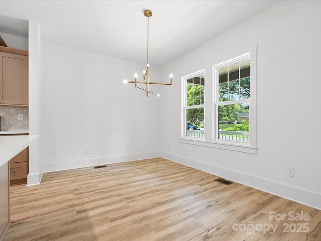 4113 Rutgers Ave, Charlotte, NC 28206 - unfurnished dining area with light wood-style floors and a chandelier