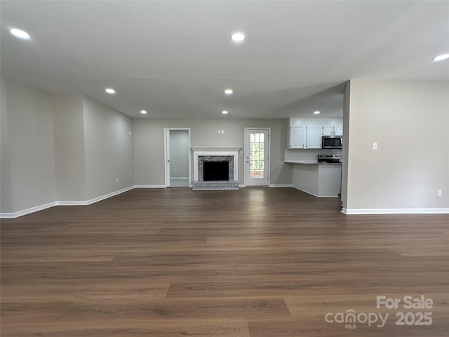 2443 1st Street Pl NW, Hickory, NC 28601 - unfurnished living room with dark wood-style flooring, recessed lighting, and a brick fireplace