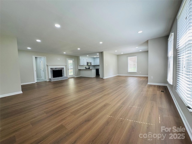 2443 1st Street Pl NW, Hickory, NC 28601 - unfurnished living room with healthy amount of natural light, dark wood-style flooring, recessed lighting, and a brick fireplace