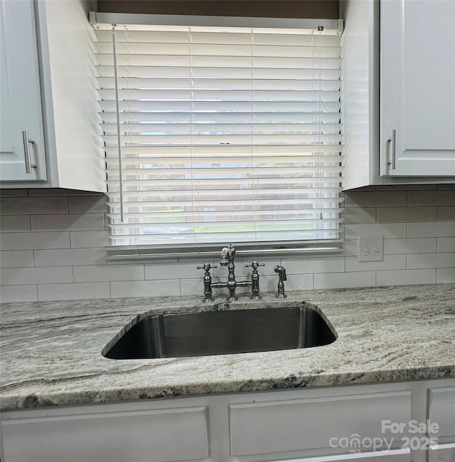 2443 1st Street Pl NW, Hickory, NC 28601 - kitchen view of white cabinetry, backsplash, and light stone counters