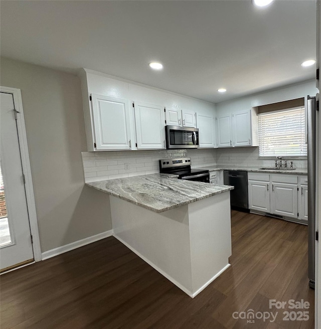 2443 1st Street Pl NW, Hickory, NC 28601 - kitchen featuring stainless steel appliances, a peninsula, dark wood-style floors, white cabinets, and recessed lighting