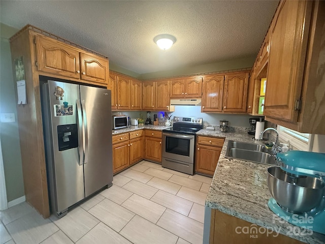 2832 Laurel Ln, Lenoir, NC 28645 - kitchen featuring stainless steel appliances, under cabinet range hood, brown cabinets, a textured ceiling, and light tile patterned floors