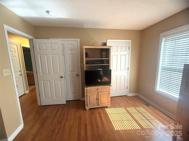 2832 Laurel Ln, Lenoir, NC 28645 - unfurnished bedroom featuring wood finished floors, a textured ceiling, and multiple windows