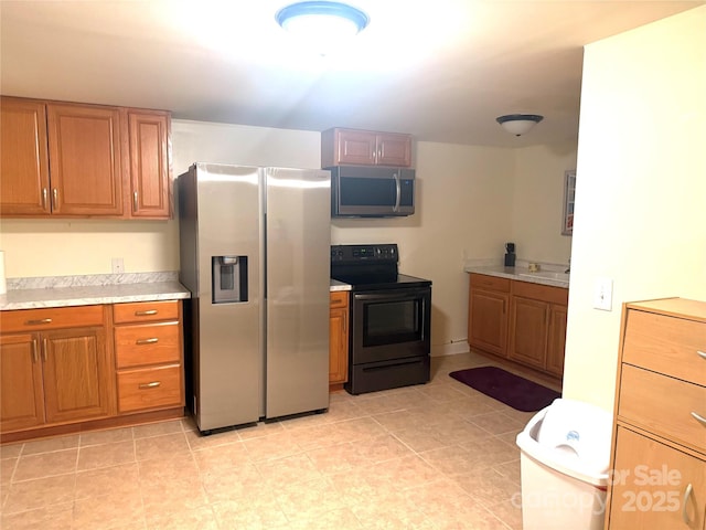 2832 Laurel Ln, Lenoir, NC 28645 - kitchen with appliances with stainless steel finishes, brown cabinets, and light countertops