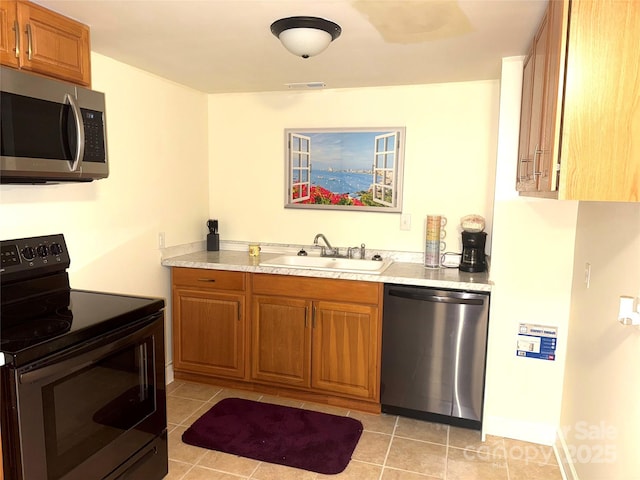 2832 Laurel Ln, Lenoir, NC 28645 - kitchen with stainless steel appliances, light countertops, light tile patterned floors, and brown cabinets