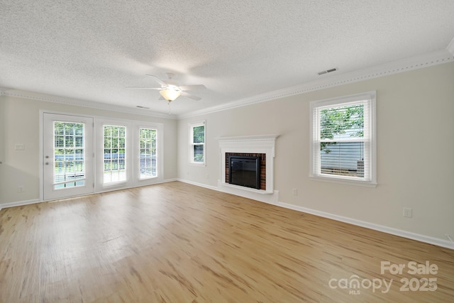 10807 Summitt Tree Ct, Charlotte, NC 28277 - unfurnished living room with ceiling fan, a textured ceiling, crown molding, light wood-type flooring, and a fireplace