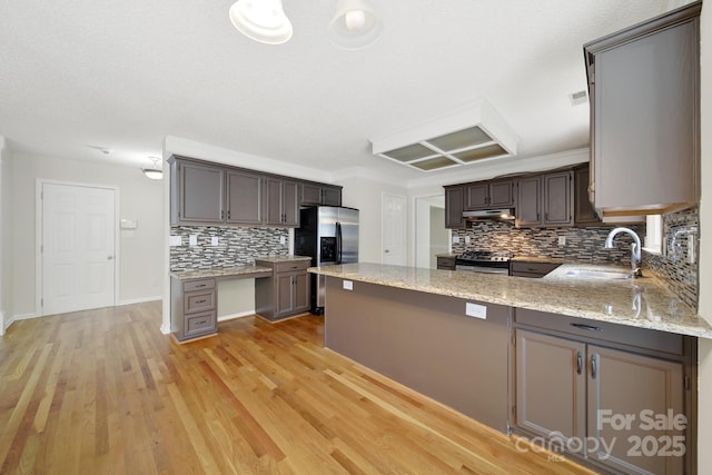 10807 Summitt Tree Ct, Charlotte, NC 28277 - kitchen featuring stainless steel appliances, decorative backsplash, light stone countertops, a peninsula, and light wood-style flooring
