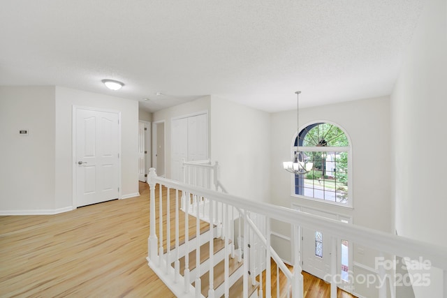 10807 Summitt Tree Ct, Charlotte, NC 28277 - corridor with an upstairs landing, a chandelier, wood finished floors, and a textured ceiling