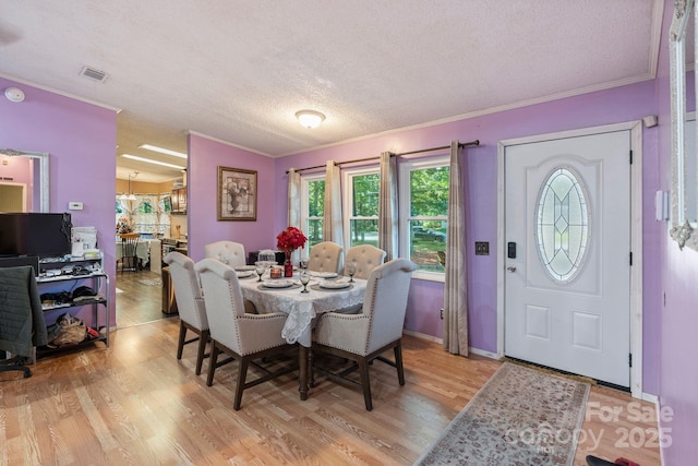115 Red Fox Ct, Mount Holly, NC 28120 - dining space with a textured ceiling, crown molding, and light wood-style floors