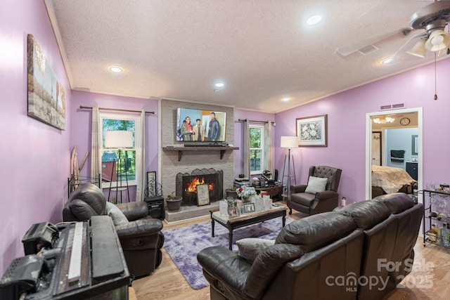 115 Red Fox Ct, Mount Holly, NC 28120 - living room featuring a textured ceiling, vaulted ceiling, ceiling fan, light wood-type flooring, and a large fireplace